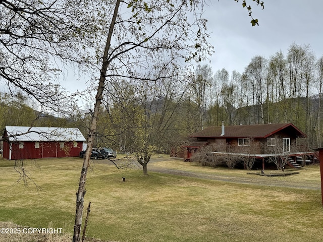 view of yard with a deck, an outdoor structure, and stairs