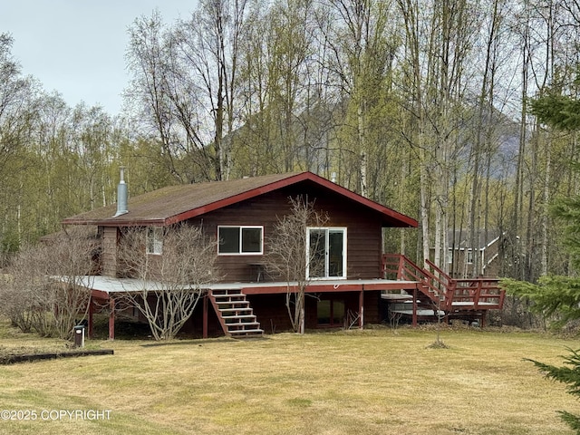 back of property with stairway, a forest view, a yard, and a wooden deck