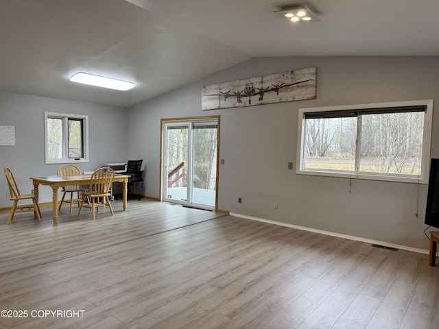 dining space featuring baseboards, vaulted ceiling, visible vents, and light wood-style floors