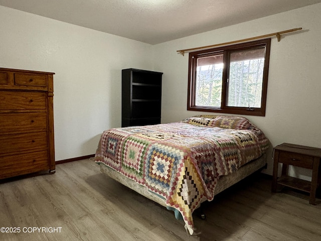 bedroom featuring baseboards and wood finished floors