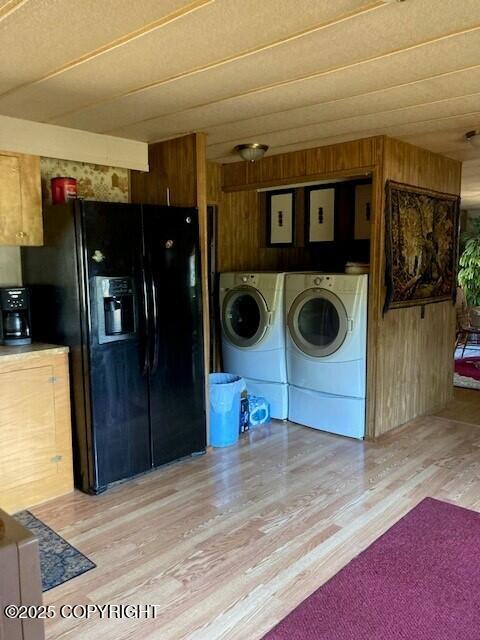 19405 Ridge St, Kasilof, AK 99610 - washroom featuring washing machine and dryer, wood walls, light wood-style floors, and laundry area
