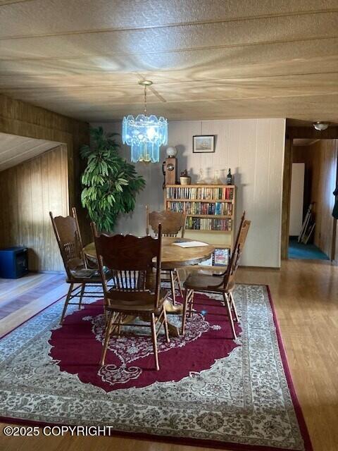 19405 Ridge St, Kasilof, AK 99610 - dining space featuring an inviting chandelier, wood finished floors, and wooden walls