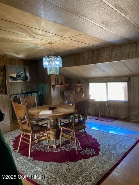 19405 Ridge St, Kasilof, AK 99610 - dining area with wooden walls, wood finished floors, and a chandelier