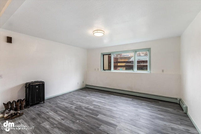 2601 E Quiet Cir, Wasilla, AK 99654 - unfurnished room with baseboards, wood finished floors, and baseboard heating