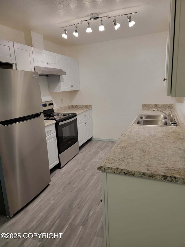 2601 E Quiet Cir, Wasilla, AK 99654 - kitchen featuring light wood-type flooring, under cabinet range hood, white cabinets, a sink, and appliances with stainless steel finishes