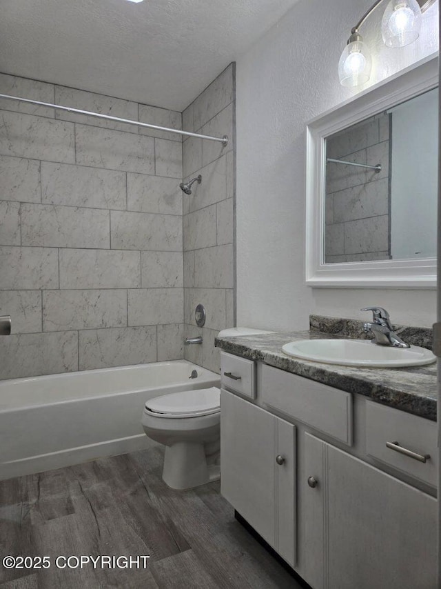 2601 E Quiet Cir, Wasilla, AK 99654 - full bath with vanity, wood finished floors, toilet, a textured ceiling, and shower / washtub combination