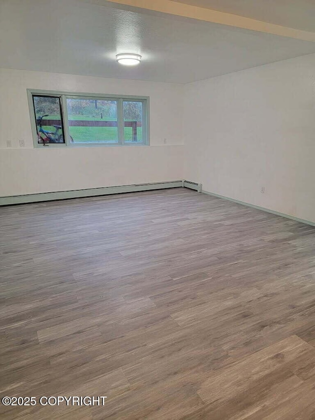 2601 E Quiet Cir, Wasilla, AK 99654 - empty room featuring baseboards, a baseboard radiator, and wood finished floors