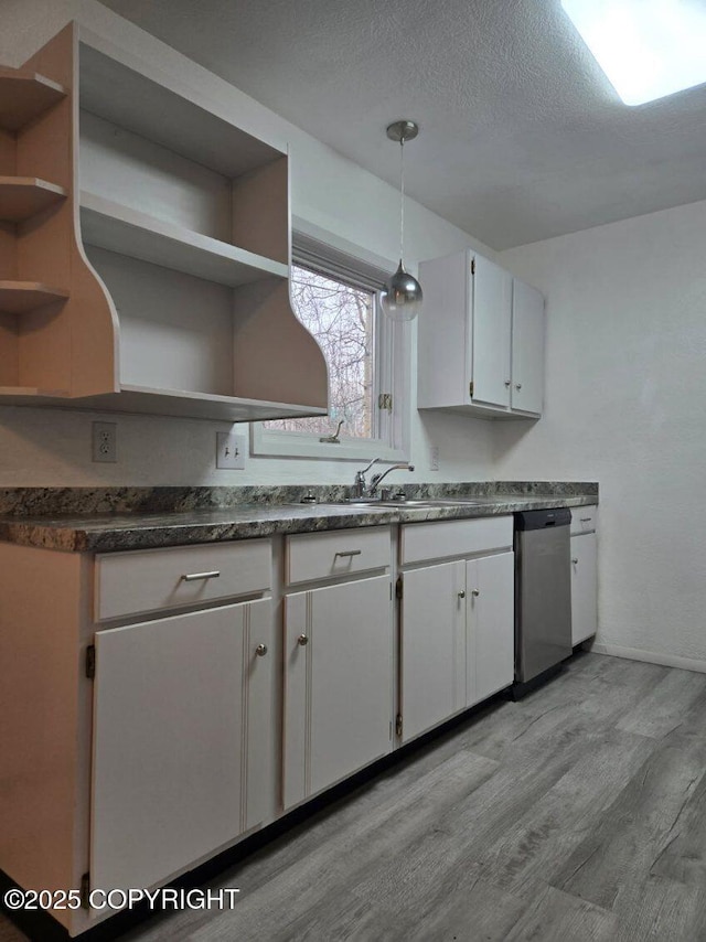 2601 E Quiet Cir, Wasilla, AK 99654 - kitchen with stainless steel dishwasher, open shelves, dark countertops, a sink, and light wood finished floors