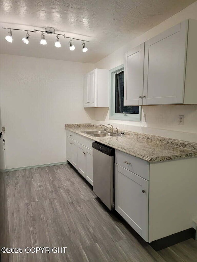 2601 E Quiet Cir, Wasilla, AK 99654 - kitchen with white cabinets, light stone counters, a sink, dishwasher, and wood finished floors