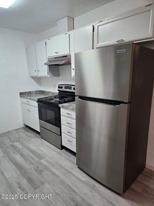 2601 E Quiet Cir, Wasilla, AK 99654 - kitchen with under cabinet range hood, stainless steel appliances, white cabinetry, and light wood-type flooring