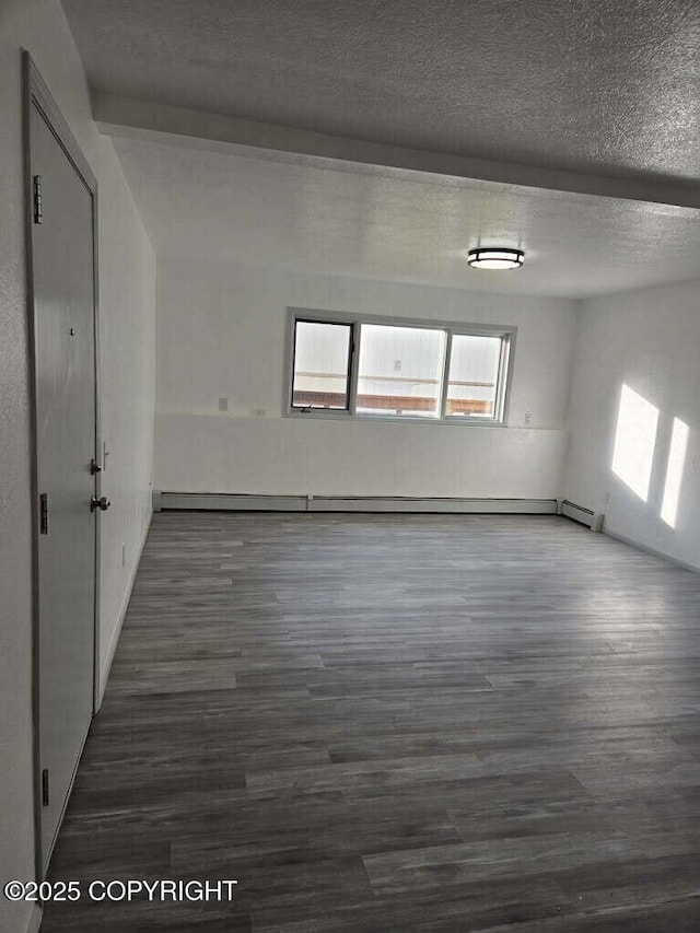 2601 E Quiet Cir, Wasilla, AK 99654 - unfurnished room featuring a textured ceiling, baseboard heating, and wood finished floors