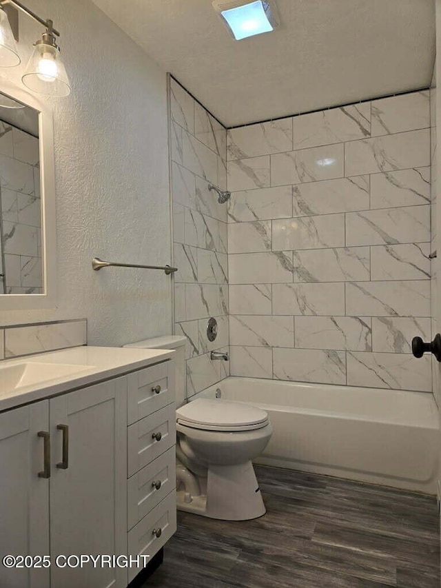 2601 E Quiet Cir, Wasilla, AK 99654 - full bath featuring a textured wall, shower / tub combination, vanity, toilet, and wood finished floors