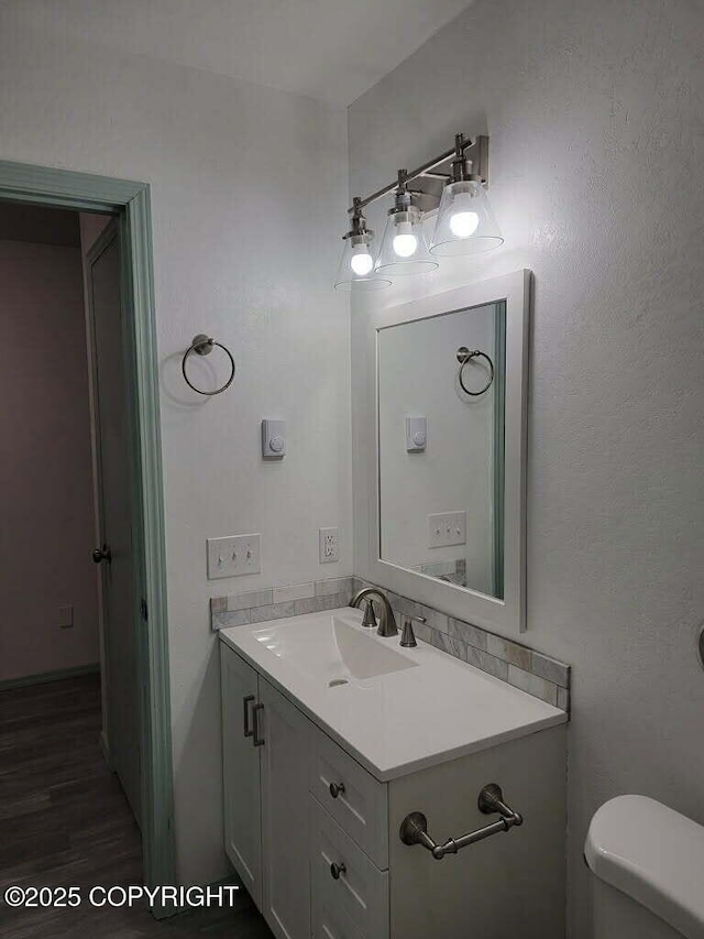 2601 E Quiet Cir, Wasilla, AK 99654 - bathroom featuring toilet, wood finished floors, and vanity