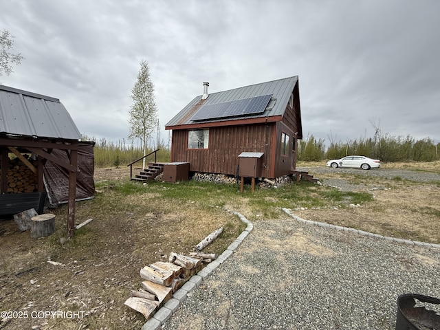 view of home's exterior featuring solar panels and metal roof