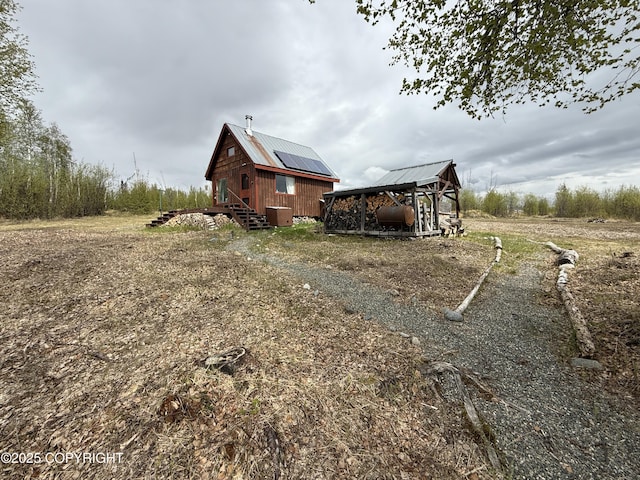 view of property exterior with metal roof and an outdoor structure