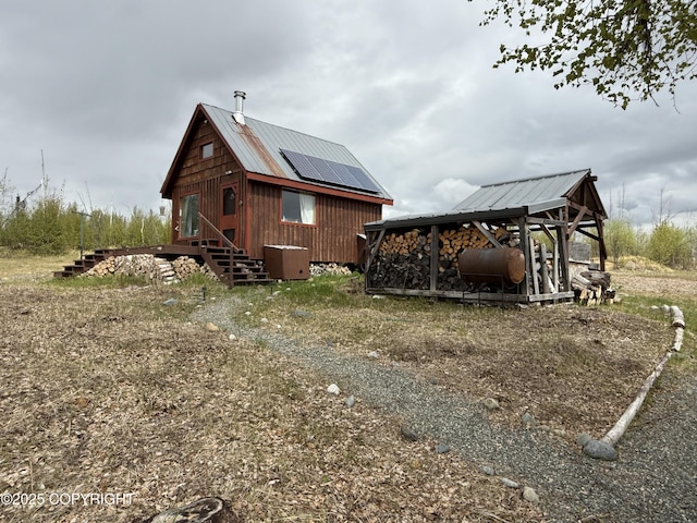 view of home's exterior featuring heating fuel, metal roof, and solar panels