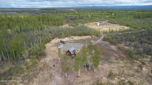 view of property location featuring a heavily wooded area and rural landscape