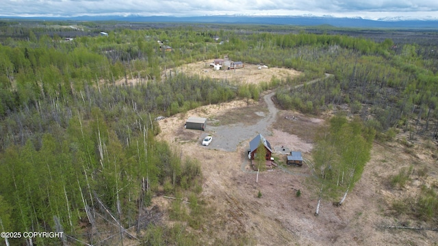 aerial view of property and surrounding area featuring a forest