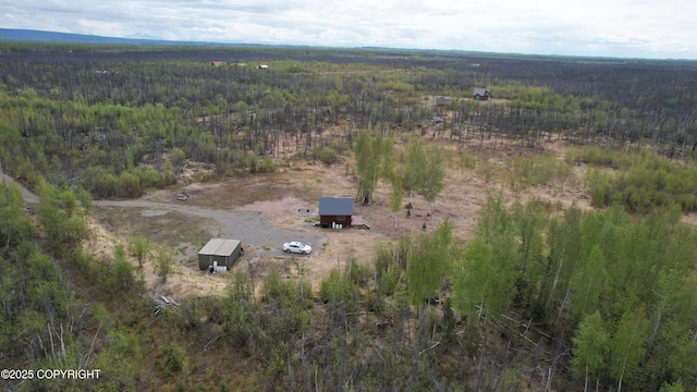 aerial view of property and surrounding area with a heavily wooded area