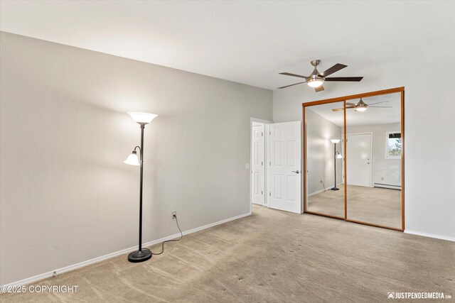 355 Donna Dr # 18, Anchorage, AK 99504 - unfurnished bedroom featuring a baseboard heating unit, a closet, carpet floors, and baseboards
