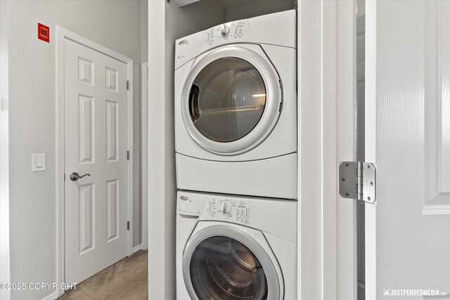 355 Donna Dr # 18, Anchorage, AK 99504 - clothes washing area featuring stacked washing maching and dryer, carpet, and laundry area