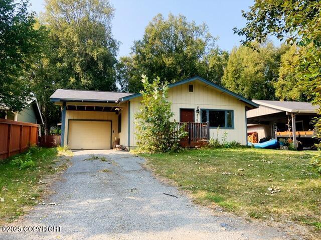 single story home featuring fence, a garage, a carport, driveway, and a front yard