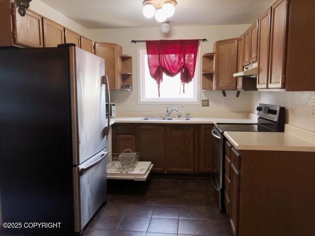 kitchen featuring dark tile patterned flooring, stainless steel appliances, open shelves, under cabinet range hood, and a sink
