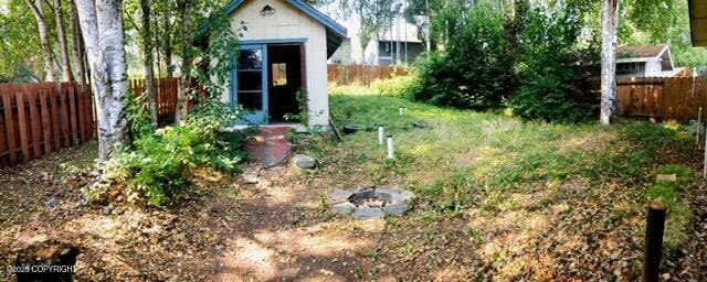 view of yard featuring an outdoor structure, a shed, and a fenced backyard