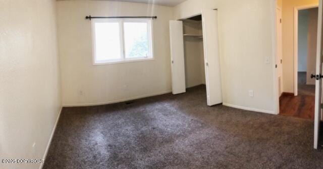 unfurnished bedroom featuring carpet floors and baseboards
