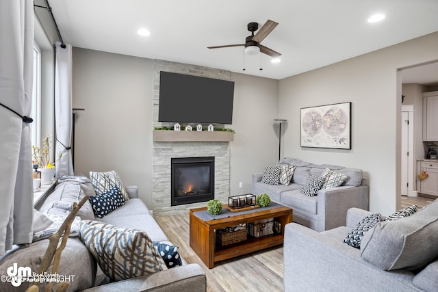 living area with a fireplace, recessed lighting, ceiling fan, and light wood-type flooring