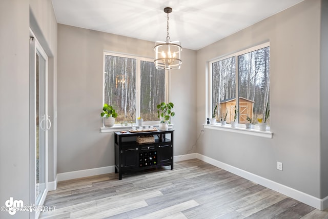 dining room with baseboards, wood finished floors, and a chandelier