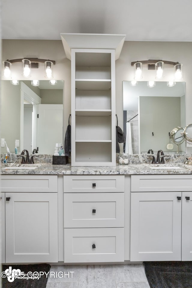 bathroom featuring a sink, a shower with curtain, and double vanity