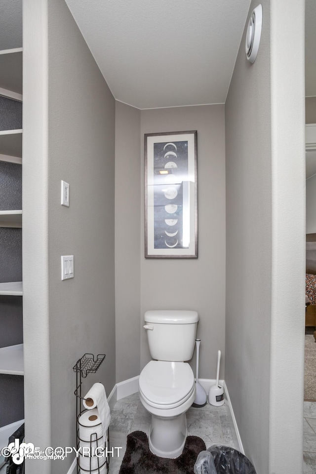 bathroom featuring baseboards and toilet