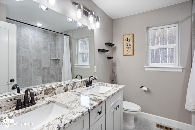 bathroom featuring a sink, baseboards, toilet, and visible vents