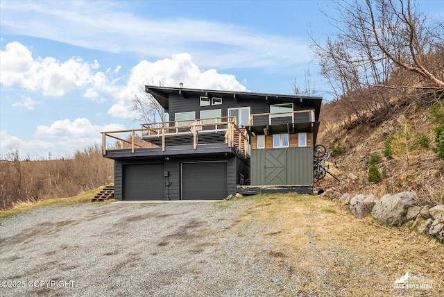 view of front facade with an attached garage, driveway, and a balcony