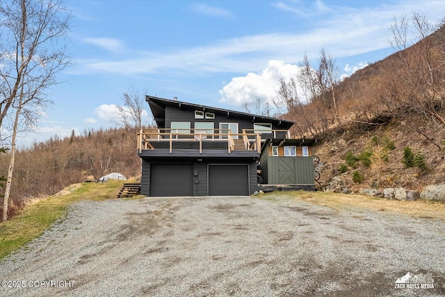 view of front of house with an attached garage, a balcony, and driveway