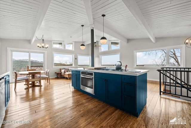 kitchen featuring an inviting chandelier, blue cabinets, beam ceiling, and oven