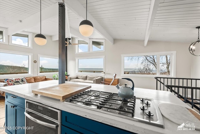 kitchen featuring pendant lighting, open floor plan, lofted ceiling with beams, blue cabinets, and stainless steel gas stovetop