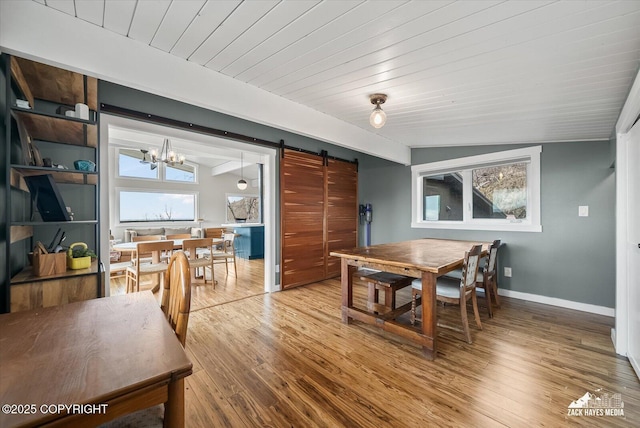 dining area featuring an inviting chandelier, wood finished floors, baseboards, a barn door, and wood ceiling