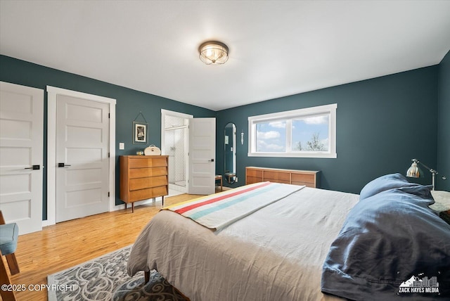 bedroom featuring arched walkways and wood finished floors
