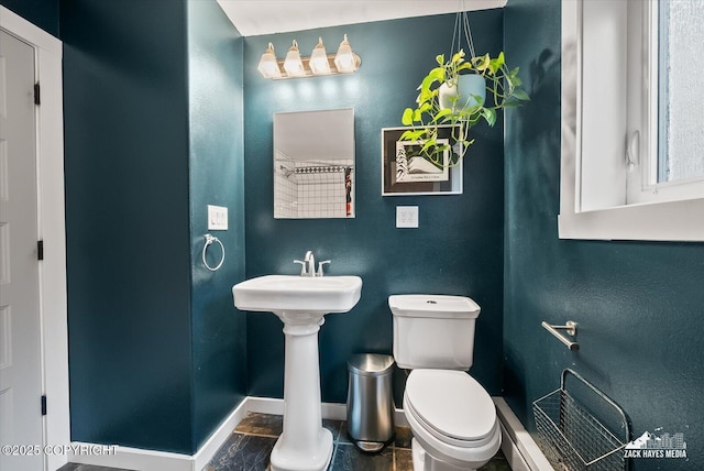 bathroom featuring toilet and baseboards