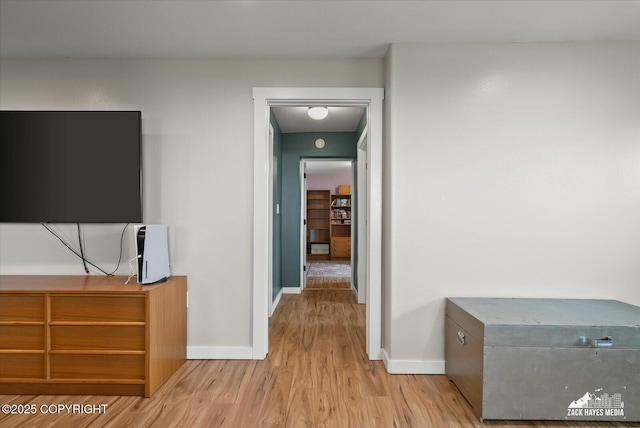 hallway featuring baseboards and wood finished floors