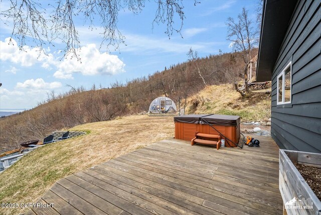 wooden terrace featuring a hot tub and a yard