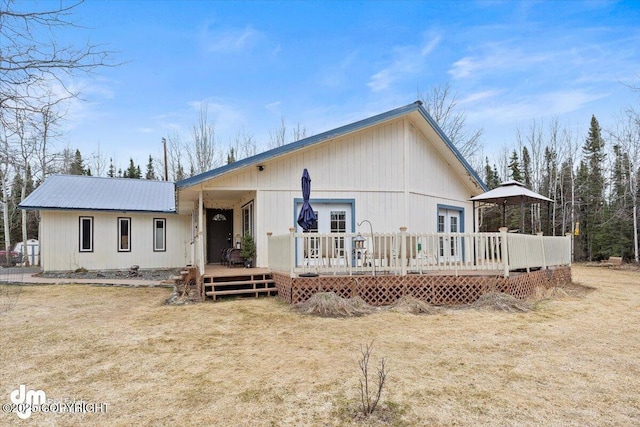 view of front of house with french doors, a wooden deck, and metal roof