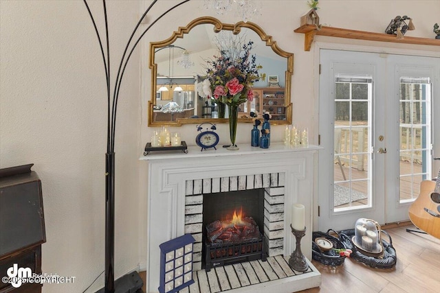 details featuring french doors, a brick fireplace, and wood finished floors