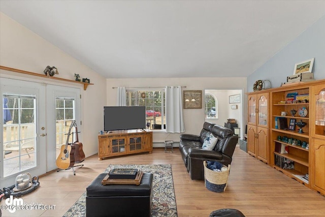 living area featuring french doors, light wood-style floors, plenty of natural light, and lofted ceiling