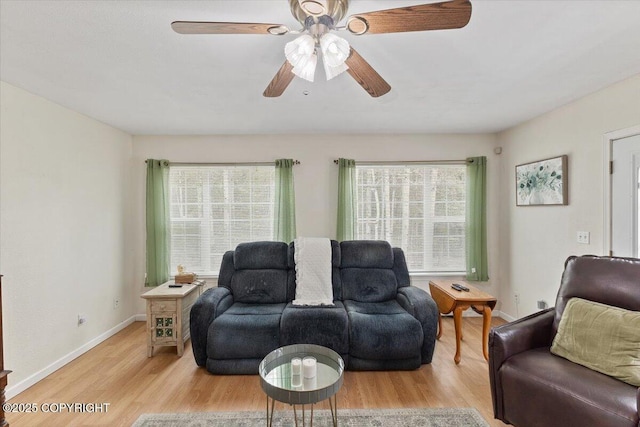 living room featuring baseboards, ceiling fan, and light wood-type flooring