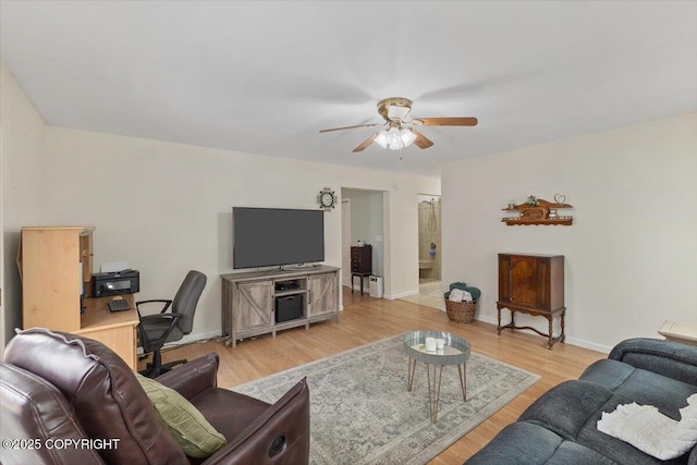 living room with baseboards, a ceiling fan, and light wood finished floors