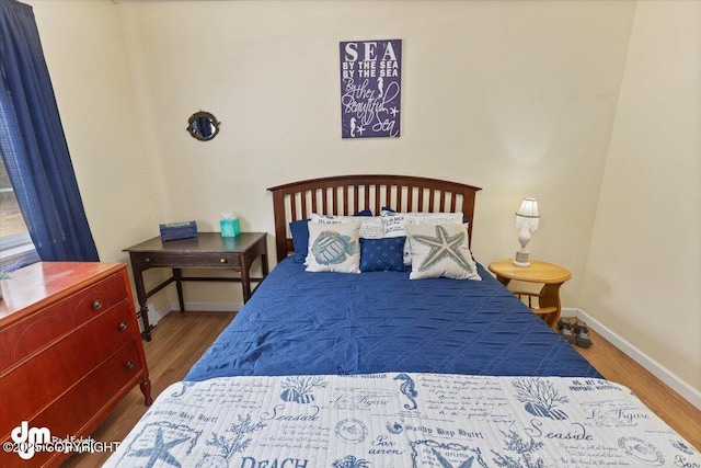 bedroom with baseboards and wood finished floors