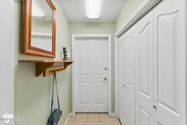 entryway with baseboards and light tile patterned floors